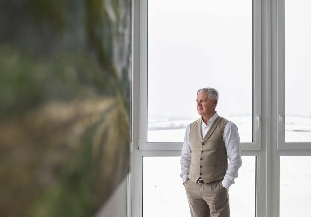 Portrait von Geschäftsführer Dr. Johann Gneist vor einem Fenster in seinem Büro