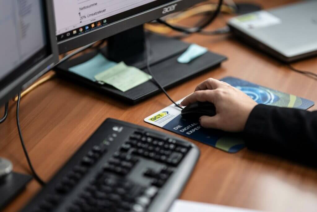 Hand auf Computermaus mit GCT-Mauspad im Einsatz am Arbeitsplatz