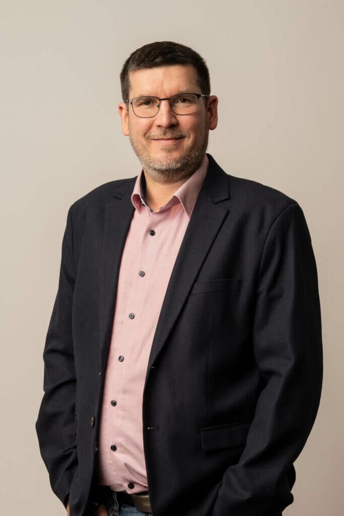 Portrait vom Payroll Accountant Michael Neuhold stehend im schwarzen Sakko.
