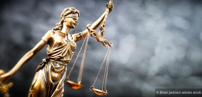 Goldene Justitia-Statue mit Waage als Symbol für rechtliche Fragen zu Zinsen und Lizenzgebühren