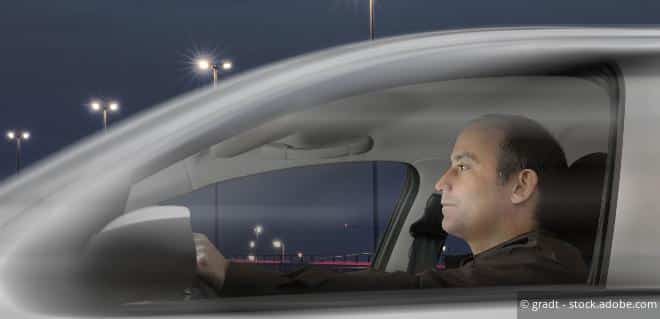 Mann sitzt im Auto – Symbol für Fahrtkosten des Vaters zum Besuch des Sohnes.