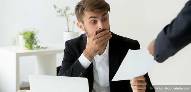 Faktischer Geschäftsführer nimmt erstaunt ein Dokument entgegen – Symbol für Verantwortlichkeit im Finanzstrafrecht.